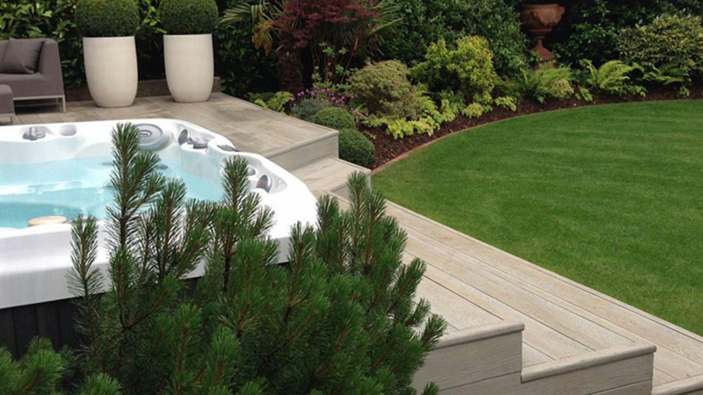 Hot tub on a wooden deck in a backyard garden